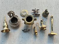 Group shot of all ten brass and bronze items on concrete background