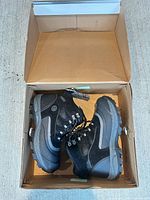 Pair of black and grey Khombu boots inside open box
