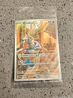 Front view of sealed Mimikyu promo card in plastic sleeve