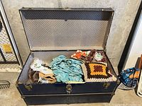 Open metal trunk revealing textiles