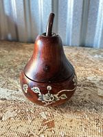Front view of wooden pear lidded box showing shape and floral carving