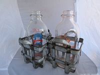 Both glass bottles each within metal carriers