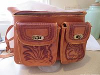 Front view showing twin pockets, tooling detail and strap