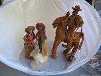 Group shot showing all four items: straw man on horse, male and female straw figures, white onyx bookend