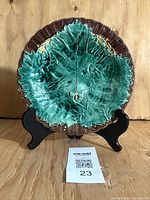 Front view of majolica plate on stand showing begonia leaf design