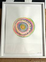 Full view of framed artwork showing concentric design and white frame