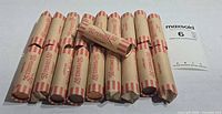 19 wrapped penny rolls with MaxSold lot card