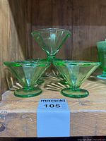 Stacked view of green uranium glass sherbet bowls showing cone shape and round foot