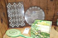 Rectangular and round glass trays with doilies, green Lucite mirror, floral collar box displayed together