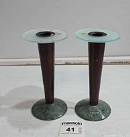 Front view of both Milano Series candlesticks showing wood shafts, glass tops, marble bases