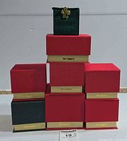 Stack of seven red Pier 1 Imports boxes with green pouch on top