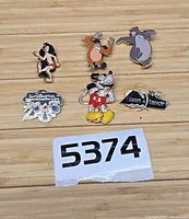 All six pins grouped on wood surface