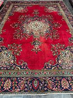 Full view of red Persian Tabriz rug showing central medallion and borders
