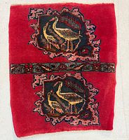 Full view of Bidjar pictorial rug showing red field, central floral band and two stork cartouches