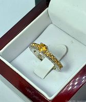 Ring in box showing citrine stones and silver band