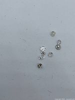 Eight loose round diamonds on white background