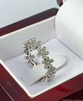 Side view of sterling silver floral CZ ring in box