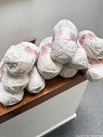 Stack of twelve cream Baby Ull yarn balls
