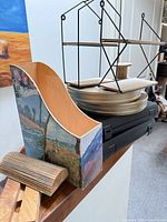 assorted items stacked: file holder, film canisters, binders, display stands, charging stand