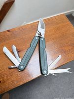 Multi-tool fully opened showing pruning shears and four auxiliary tools