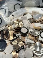 Pile of square, round metal dials and packaged crystals