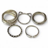 Five sterling silver rings laid out to show designs
