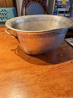 Full view of oval metal ice bucket showing shape, handle and decorative inner rim band