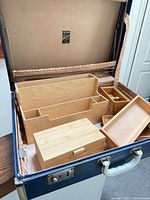 Open suitcase showing interior label, lining and wood organizers