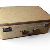 Top view of beige fabric suitcase with brown trim and handle