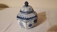 Front view of hexagonal blue and white porcelain jar with lid