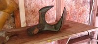 Side view of cast iron horned cobbler's anvil on shelf