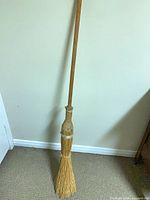 Full view of broom leaning against wall