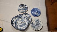 Front view of all seven blue and white transferware plates