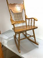 Full view of oak rocking chair on table