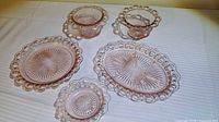 Five pink Depression glass pieces arranged on table