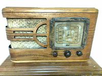 Front view showing cabinet, dial, knobs, grill cloth