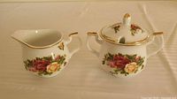 Creamer and covered sugar bowl side by side showing pattern and size