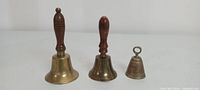 All three brass hand bells upright showing relative sizes