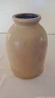 Full view of beige stoneware crock jar showing overall form and color