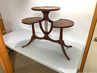 Full view of walnut lyre-back triple-tier table