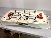 Full view of tabletop rod hockey game with players, nets and rods