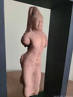 Front three-quarter view of pink sandstone Avalokiteshvara Bodhisattva torso in wood frame