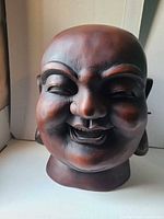 Front view of carved wood Laughing Buddha head