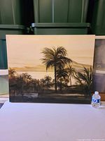 Full view of framed painting showing palm tree landscape