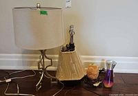 All four lamps grouped: metal table lamp with shade, wrapped trapezoid lamp base, Himalayan salt lamp, lava lamp