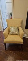 Front view of Fairfield yellow patterned armchair with sequin pillow