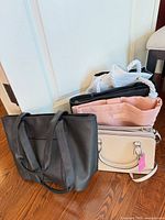 Group of five purses lined up on floor showing overall condition and colours