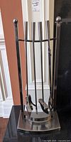 Full view of metal fireplace tool set on stand