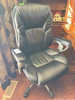 Front view of black Serta executive chair showing upholstery, armrests and caster base