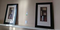 Both framed prints side by side on ledge